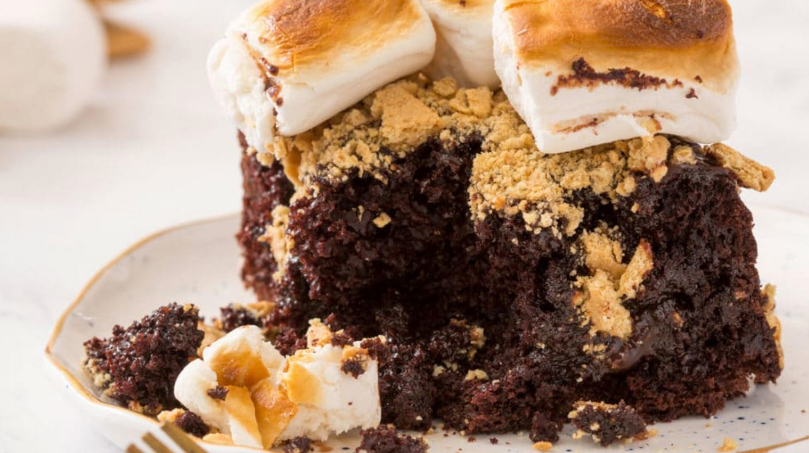 The side of Miss Jones Baking Chocolate S’mores Poke Cake with toasted marshmallows on top